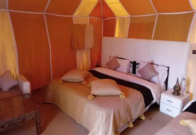 a bedroom with two beds in a tent at Amodo desert camp in Merzouga