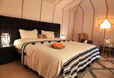 a bedroom with a bed with a bowl of fruit on it at Amodo desert camp in Merzouga