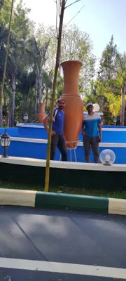 two men are standing next to a large vase at Hôtel flora in Beni Mellal