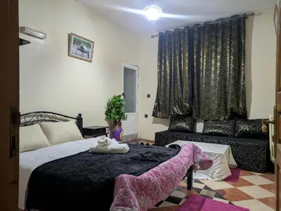 a bedroom with a large bed and a couch at Maison d'hôtes de Zaida in Zaida