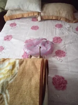 a bed with a white comforter with pink roses on it at Chez l habitant mayorka in Sefrou