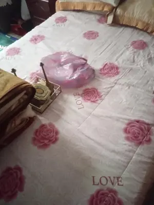 a bed with pink roses on it with the words love at Chez l habitant mayorka in Sefrou