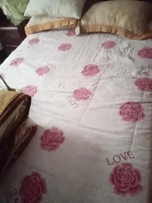 a bed with pink roses on it with the words love at Chez l habitant mayorka in Sefrou