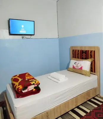 a room with a bed with a tv on the wall at Tagmat guest house in Toufrine