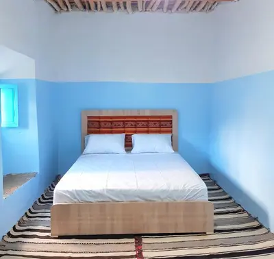 a bed in a room with a blue wall at Tagmat guest house in Toufrine