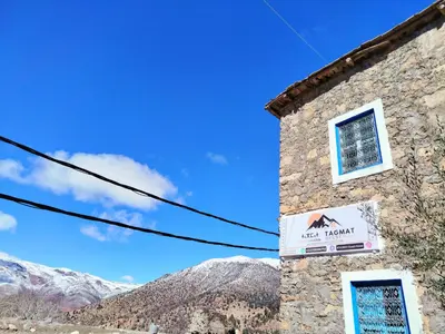 a building with a sign on the side of it at Tagmat guest house in Toufrine