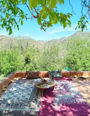 a patio with a table and a view of mountains at Tagmat guest house in Toufrine