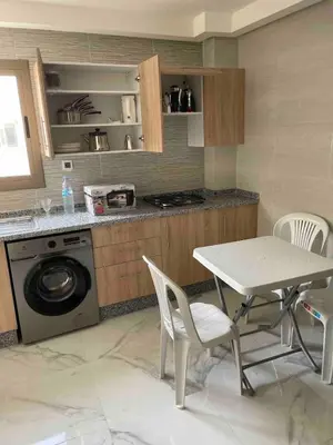 a kitchen with a table and chairs and a washing machine at Maison avec ascenseur in Fès