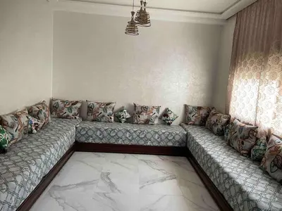 a living room with a long couch with pillows at Maison avec ascenseur in Fès