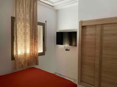 a bedroom with a bed and a television on the wall at Maison avec ascenseur in Fès