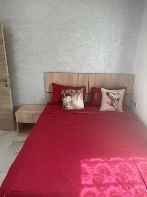 a red bed with pillows on it in a bedroom at Maison avec ascenseur in Fès