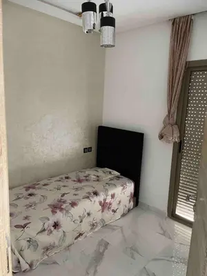 a bedroom with a bed with a floral bedspread at Maison avec ascenseur in Fès