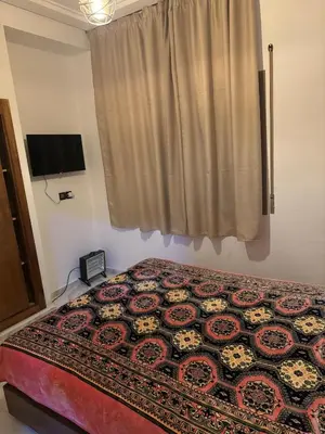 a bedroom with a bed and a window and a television at Chic and comfortable air-conditioned apartment in Fès