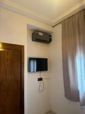 a room with a television on the corner of a wall at Chic and comfortable air-conditioned apartment in Fès