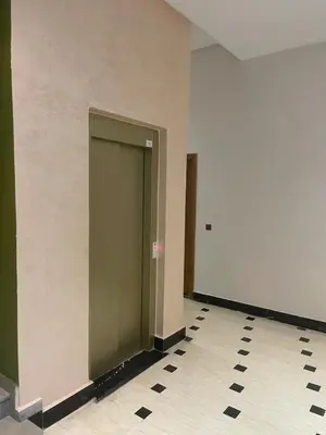a hallway with a green door and a tile floor at Chic and comfortable air-conditioned apartment in Fès
