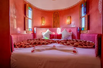 a bedroom with a large bed with pink walls at Atlas Castle Marrakech in Marrakech