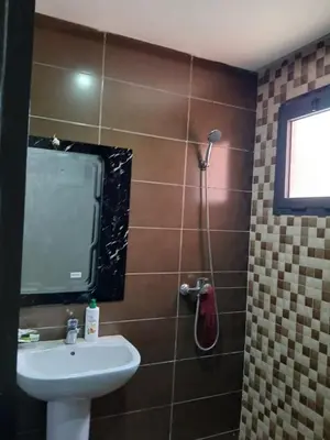 a bathroom with a shower with a sink and a mirror at Appartement a marrakech in Oulad Akkou