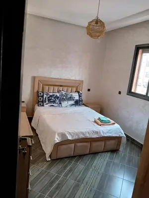 a bedroom with a bed with blue and white pillows at Appartement a marrakech in Oulad Akkou
