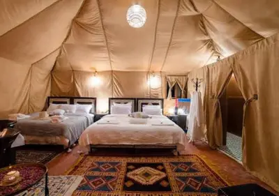 a bedroom with two beds in a tent at Sahara Starlight Luxury Camp in Merzouga