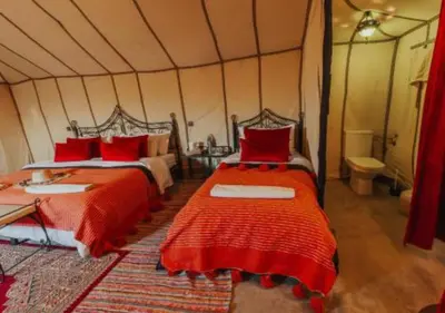 a bedroom with two beds in a tent at Sahara Starlight Luxury Camp in Merzouga