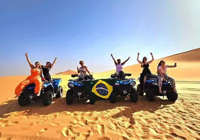 a group of people on atvs in the desert at Sahara Starlight Luxury Camp in Merzouga
