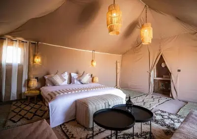 a bedroom with a bed in a tent at Sahara Starlight Luxury Camp in Merzouga