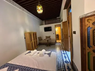 a bedroom with a bed and a chandelier at Riad Joseph in Fès