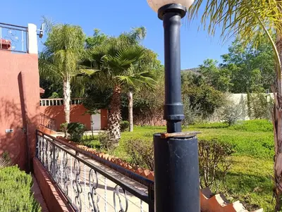 a black light pole next to a fence with palm trees at Villa montysco in Hal Sabek