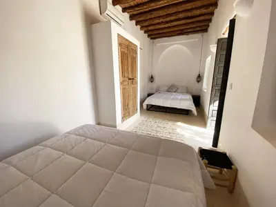 a bedroom with a large bed in a room at Villa les 3 Palmiers B&B in Jdiouat