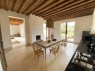 a kitchen and dining room with a table and chairs at Villa les 3 Palmiers B&B in Jdiouat