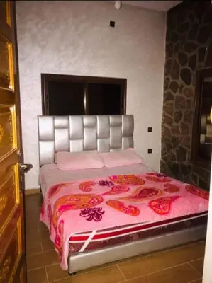 a bedroom with a large bed with a pink blanket at villa maya in Ourika