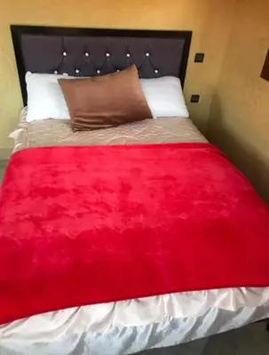 a bed with a red blanket on top of it at villa maya in Ourika