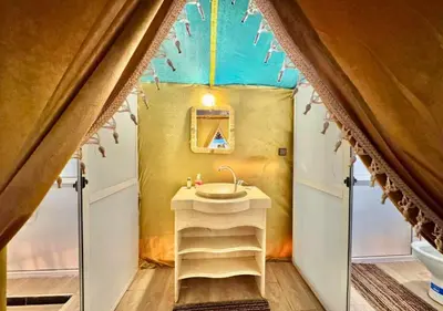 a small bathroom with a sink in a tent at Moroccan luxury camp in Merzouga