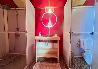 a bathroom with a sink and a mirror and a toilet at Moroccan luxury camp in Merzouga