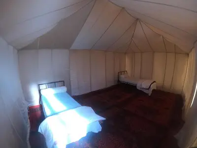 a room with two beds in a tent at camp marhaba iriki in Alougoum