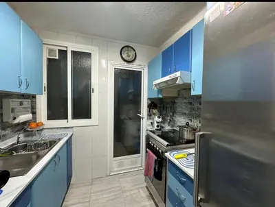 a kitchen with blue cabinets and a stainless steel refrigerator at inozar in Azrou
