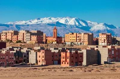 a group of buildings in front of a snowy mountain at inozar in Azrou