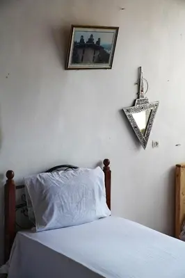 a bedroom with a bed and a picture on the wall at Gite Cathedrale Imsfrane in Temga