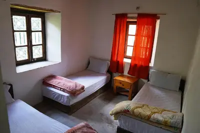 a room with three beds and two windows at Gite Cathedrale Imsfrane in Temga