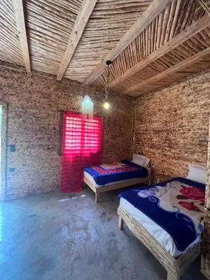 a room with two beds and a red window at Gite Cathedrale Imsfrane in Temga