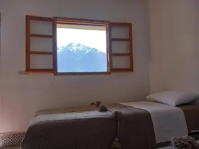 a bedroom with a window with a view of a mountain at yagour hebergement in Setti Fatma