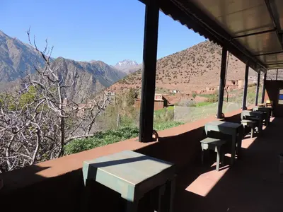 a room with benches and a view of a mountain at yagour hebergement in Setti Fatma