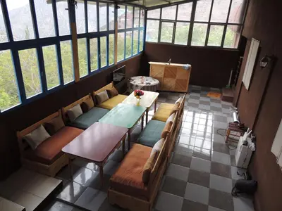 a room with a table and chairs and windows at yagour hebergement in Setti Fatma