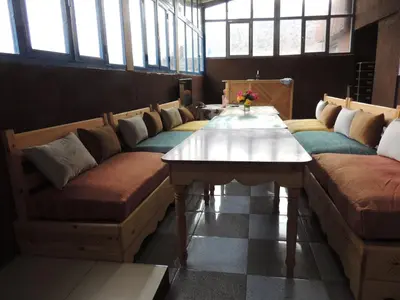 a room with couches and a table with flowers on it at yagour hebergement in Setti Fatma