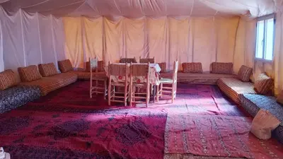 a room with a table and chairs in a tent at Iriki Desert Camp Foum Zguid in Foum Zguid