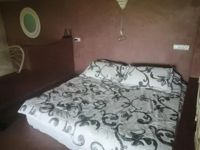 a bed with a black and white comforter at Maison au lac bin el ouidane in Tillouguit nʼAït Isha