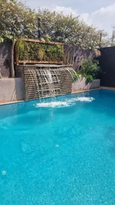 a waterfall in a pool with blue water at Maison au lac bin el ouidane in Tillouguit nʼAït Isha