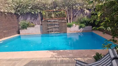 a swimming pool with blue water in a backyard at Maison au lac bin el ouidane in Tillouguit nʼAït Isha