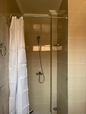 a shower with a shower curtain in a bathroom at Dyafat Abla in Ouarzazate