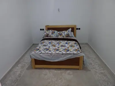 a bedroom with a bed with a wooden frame at apartment for rent by days in Zagora
